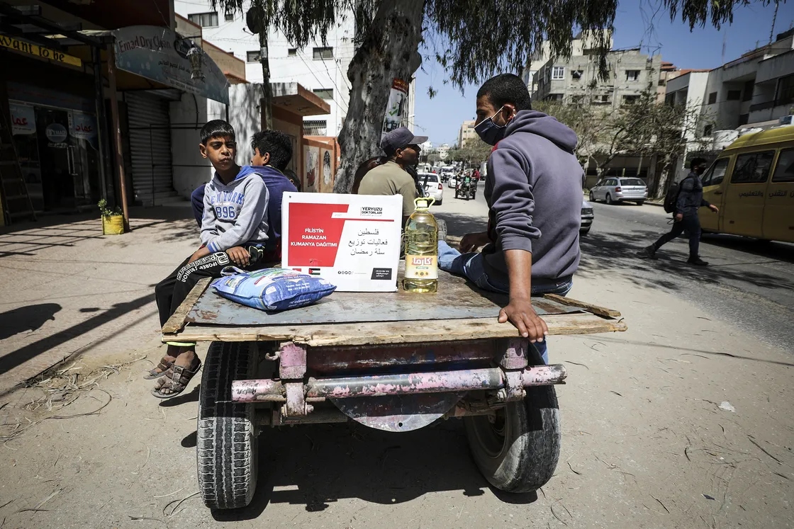 Người dân nhận các gói viện trợ thực phẩm do các quan chức của Tổ chức Bác sĩ Toàn cầu Thổ Nhĩ Kỳ phân phát ở thành phố Gaza. Ảnh: Getty Images