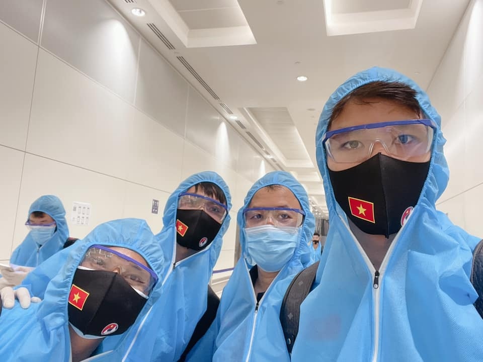 Các thành viên ĐT Việt Nam mặc đồ bảo hộ trước khi xuống sân bay Dubai làm thủ tục nhập cảnh vào UAE.