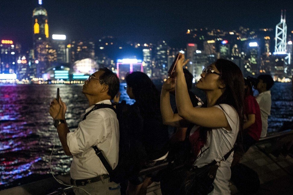 Người dân chụp ảnh nguyệt thực từ Đại lộ Ngôi sao ở Hong Kong vào tháng 10/2014. Ảnh: AFP.