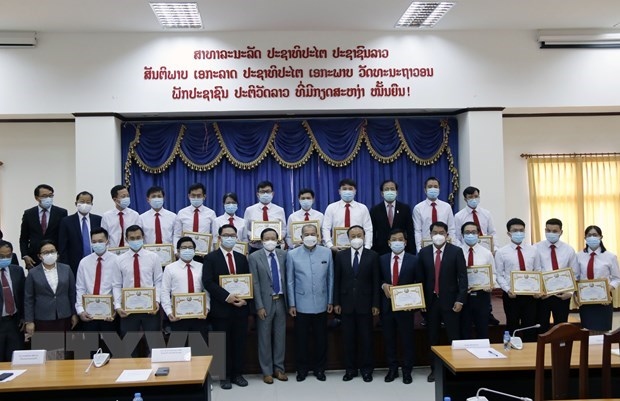 Lao Deputy Prime Minister Kikeo Khaykhamphithoune (centre) and officials pose for a group photo with Vietnamese medical experts.