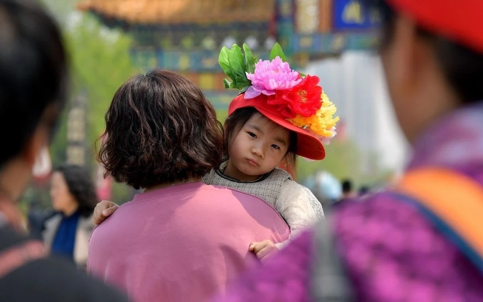 Bé gái Trung Quốc được bế đi chơi công viên ở tỉnh Sơn Đông. Ảnh: Tân Hoa xã.