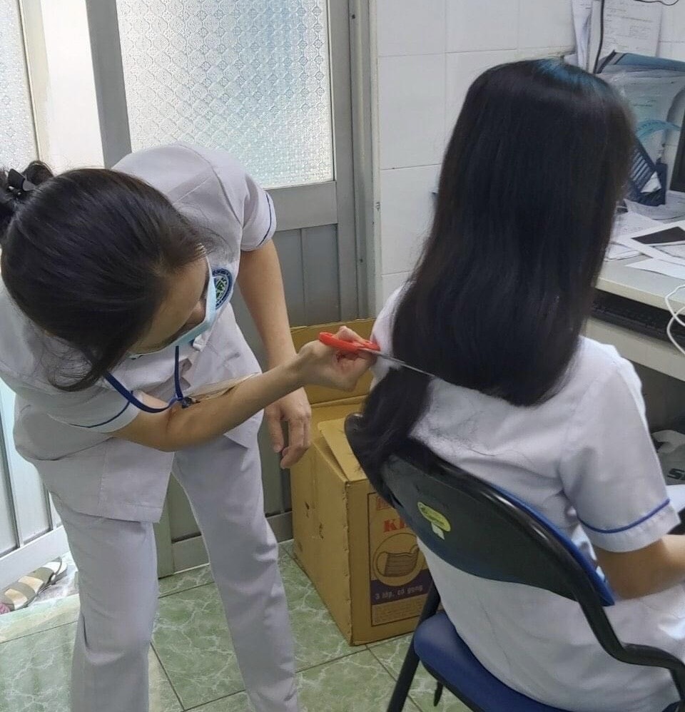 Nhân viên y tế BV Da Liễu TP.HCM cắt tóc giúp nhau để chuẩn bị vào hỗ trợ khu cách ly tập trung (Ảnh: Fanpage BV)