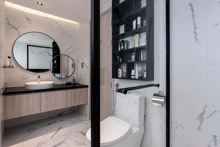 Phòng vệ sinh nhỏ gọn nhưng tiện nghi. Tường ốp đá cẩm thạch mang lại cảm giác sang trọng. Gương chậu rửa được thiết kế như một tác phẩm trang trí.