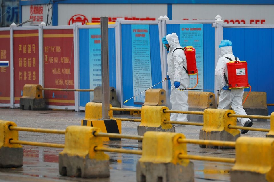 Các nhân viên phun khử khuẩn tại một khu chợ ở Vũ Hán, tỉnh Hồ Bắc tháng 3/2021. Ảnh: Reuters