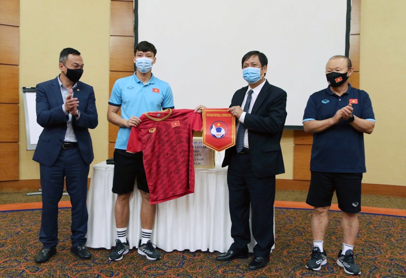Đội trưởng Quế Ngọc Hải đại diện các cầu thủ đội tuyển tặng áo thi đấu, cờ lưu niệm cho Đại sứ Nguyễn Mạnh Tuấn (Ảnh: VFF).