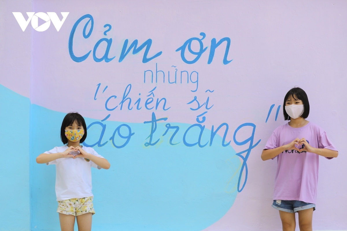 Children take photos alongside the mural paintings, sending their sincere thanks to healthcare workers and soldiers who work hard all day in the country’s ongoing fight.