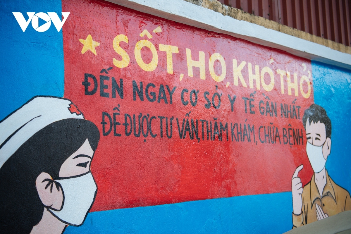 A mural painting warns local people who show symptoms such as a fever, a cough, or shortness of breath, to head to their nearest healthcare station for examination and treatment.