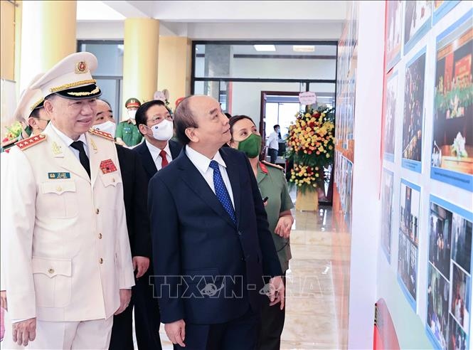 Chủ tịch nước Nguyễn Xuân Phúc tham quan trưng bày ảnh về các hoạt động của lực lượng An ninh nhân dân. Ảnh: Thống Nhất/TTXVN