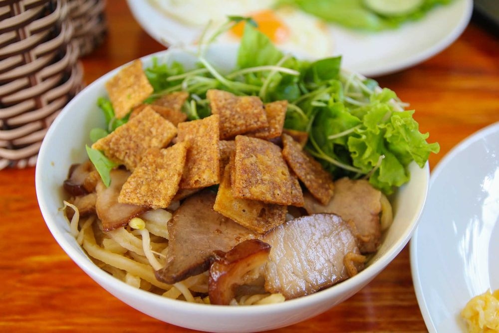 Cao lau (noodle bowl) is one of Hoi An’s most tasty specialties. The mouthwatering bowl includes thick rice-flour noodles, bean sprouts, and pork-rind croutons which are served in a light soup.