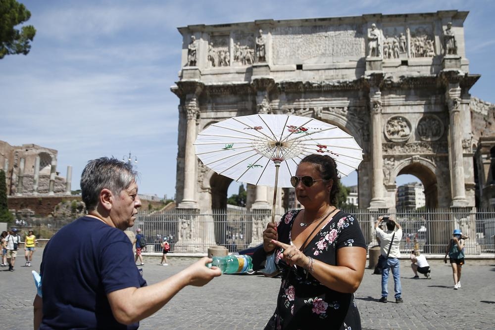 Tình nguyện viên phát nước uống cho du khách tại khu vực Đấu trường La Mã, Rome. Nguồn: AP