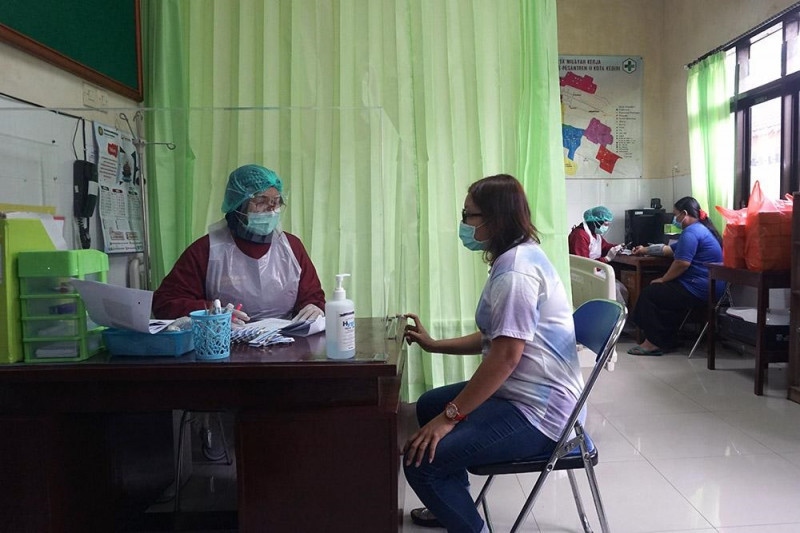 Bác sĩ khám sàng lọc trước khi tiêm cho một phụ nữ mang thai ở Kediri, Đông Java, Indonesia. Nguồn: Antara