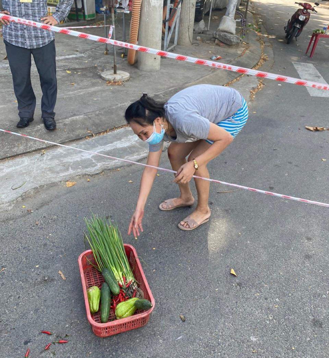 Một người dân trên đường Bùi Dương Lịch, phường Nại Hiên Đông nhận rau củ từ tổ chức từ thiện.