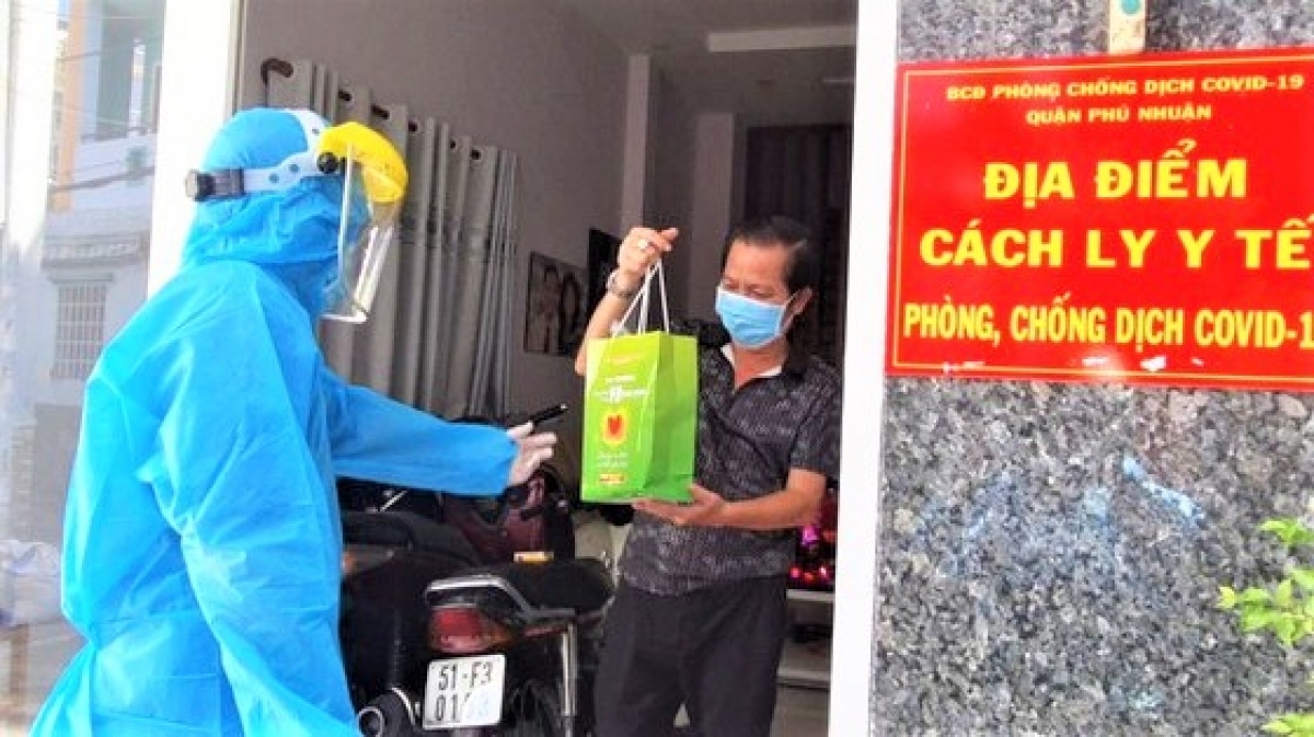 Đội hình 'Đồng hành cùng F0 khỏi bệnh' trao túi thuốc và hướng dẫn bệnh nhân F0 đang điều trị tại nhà ở quận Phú Nhuận. (Ảnh: HCDC).