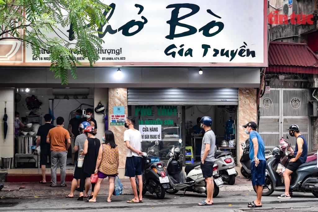 Local residents in safe areas queue up to buy Pho Bo (beef noodle soup)