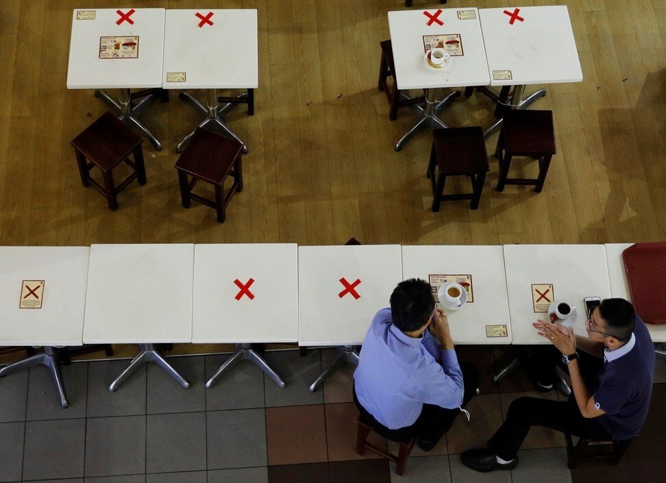 Những chiếc bàn được đánh dấu để thực hiện giãn cách tại một quán café ở Singapore. Ảnh: Reuters