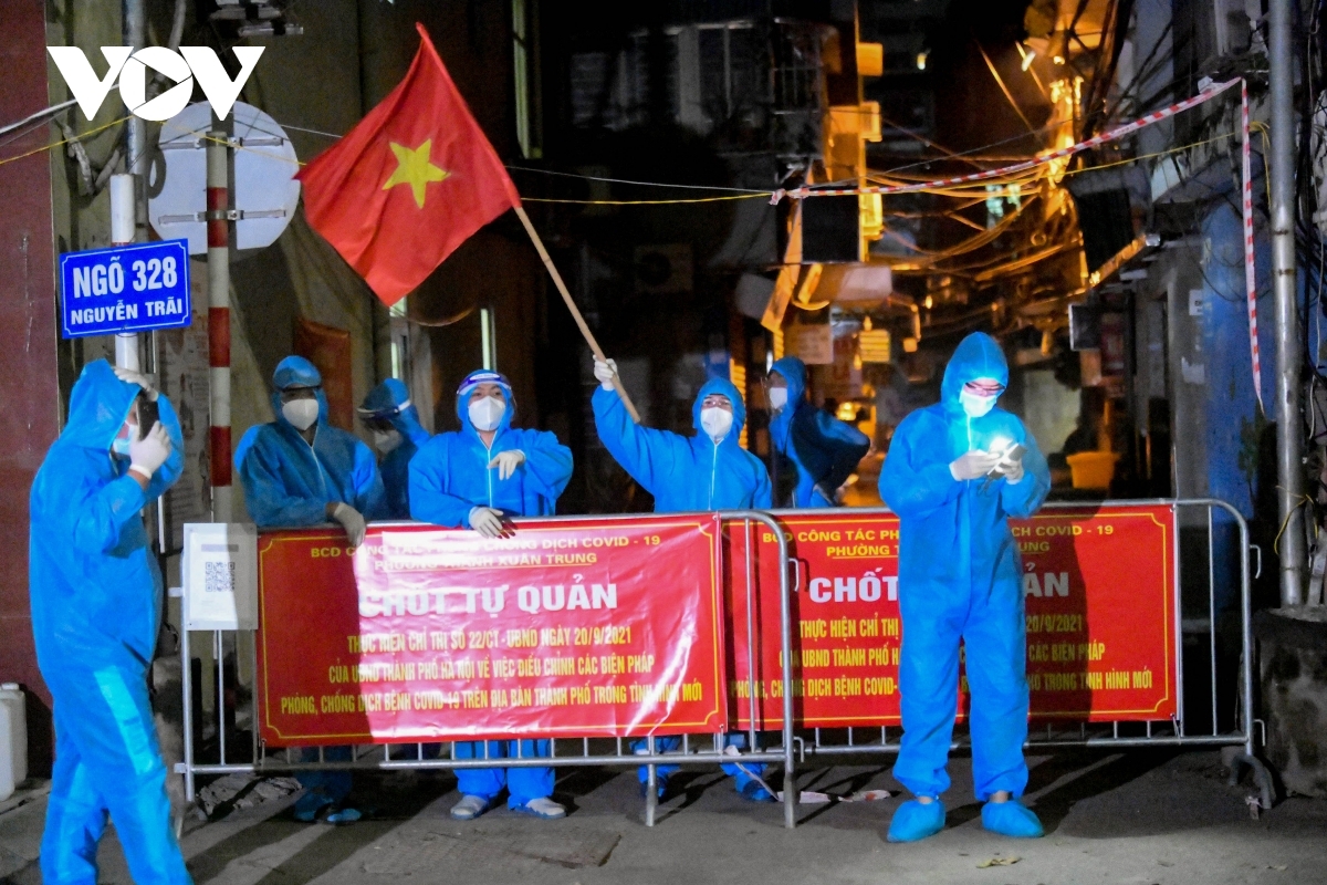 Locals wave the national flag and show their joy at the isolated area being removed lockdown on September 29.