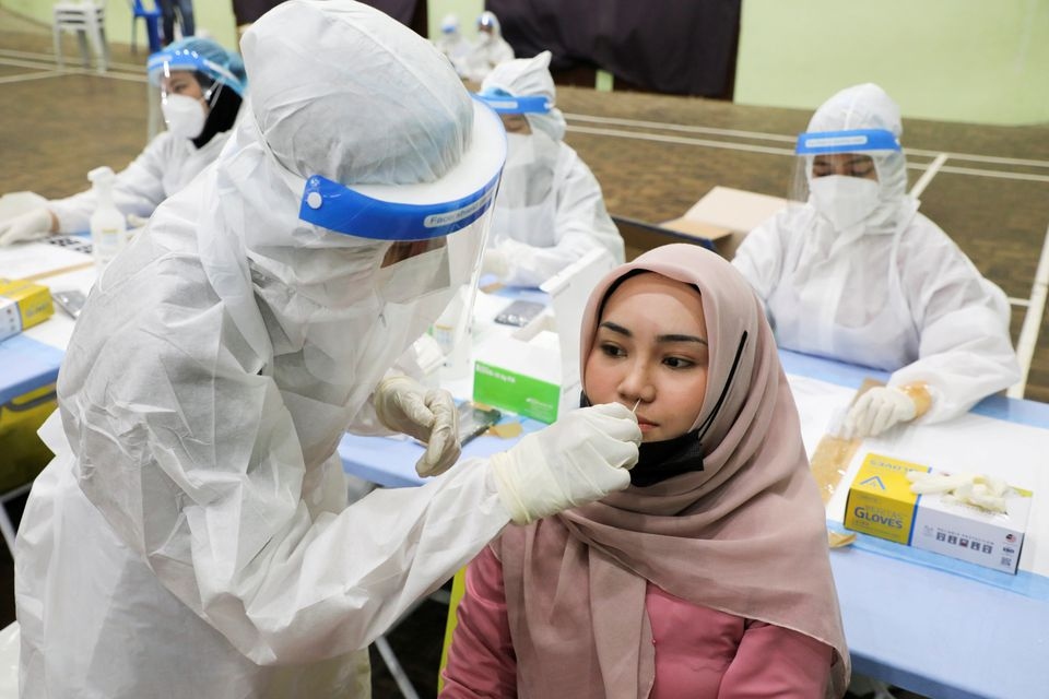 Một nhân viên y tế lấy mẫu xét nghiệm Covid-19 cho một phụ nữ ở Kuala Lumpur, Malaysia ngày 11/5/2021. Ảnh: Reuters