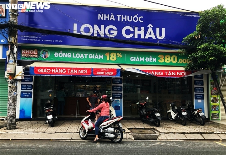 Local people follow the Health Ministry’s 5K message at a drug store located on Le Van Luong street, with the majority of buyers fully vaccinated against the COVID-19 pandemic.