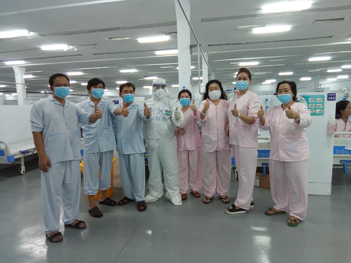 COVID-19 patients pose for a photo with medical staff before being discharged from hospital (Photo: nld.com.vn)