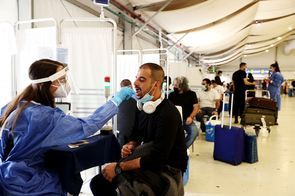 Nhân viên y tế lấy mẫu xét nghiệm COVID-19 cho du khách tại sân bay Ben Gurion (Israel) hôm 13/10. Nguồn: Reuters