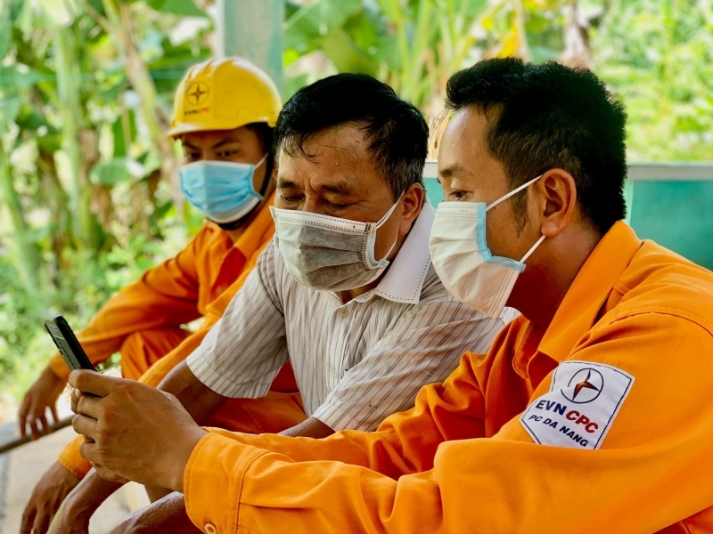 Nhân viện Điện lực hướng dẫn khách hàng cách kiểm tra thông tin tiêu thụ điện trên thiết bị điện tử.