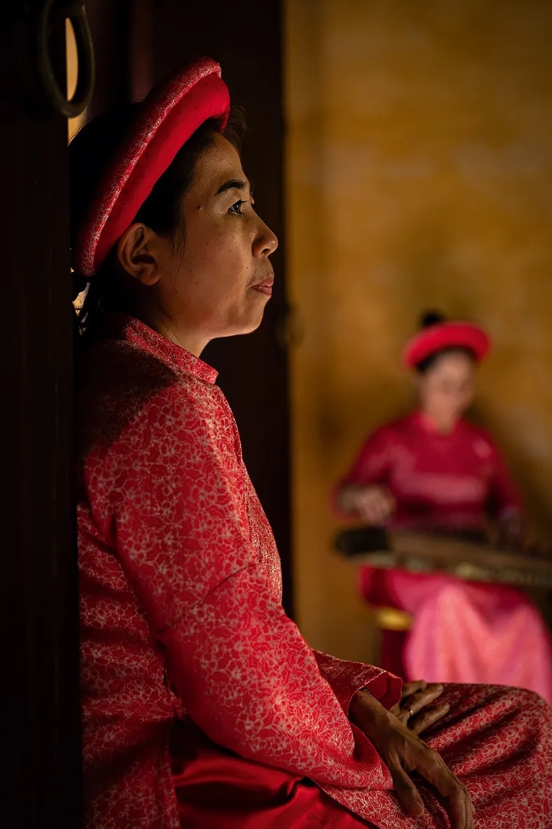 Vietnamese woman in traditional clothing in the Imperial City of Hue by Walter Monticelli.