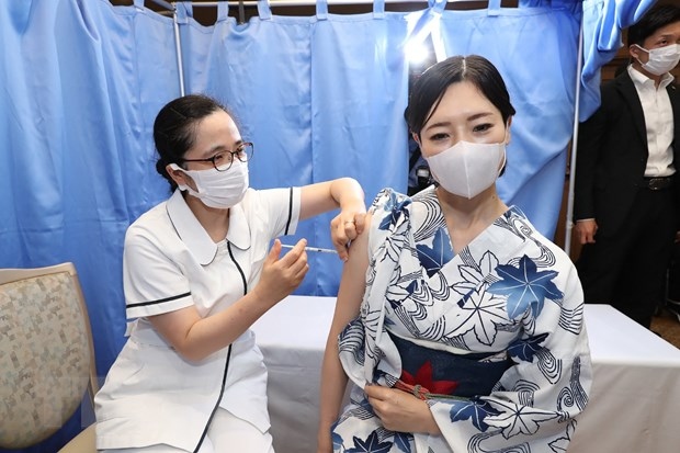 Nhân viên y tế tiêm vaccine ngừa COVID-19 cho người dân tại Tokyo, Nhật Bản. (Ảnh: AFP/TTXVN)