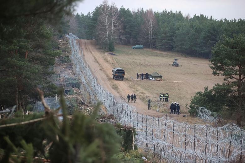 Các nước EU cáo buộc Minsk cố ý làm leo thang khủng hoảng và thúc giục áp đặt các biện pháp trừng phạt đối với Belarus. Trong khi đó, Tổng thống Belarus - Alexander Lukashenko lại cho rằng trách nhiệm thuộc về các quốc gia phương Tây. Trong ảnh: Các nhân viên thực thi pháp luật Ba Lan đi dọc hàng rào ở biên giới Belarus-Ba Lan ở vùng Grodno, Belarus ngày 18/11.
