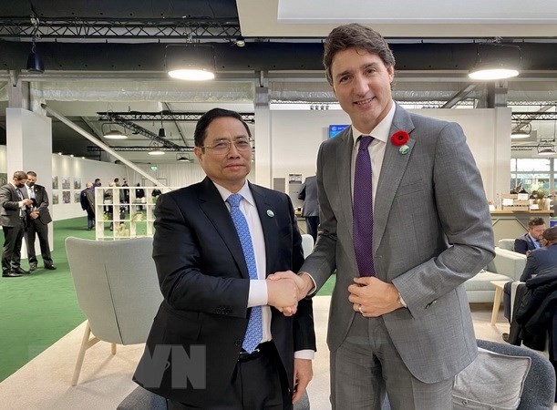 Prime Minister Pham Minh Chinh (L) shakes hand with Canadian Prime Minister Justin Trudeau in Glasgow, Scotland, on the sidelines of the UN Climate Change Conference. (Photo: VNA)