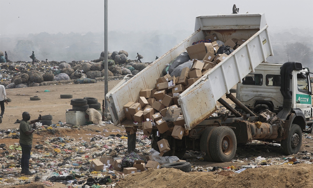 Xe tải đổ thùng đựng vaccine Covid-19 AstraZeneca hết hạn xuống bãi rác ở thủ đô Abuja, Nigeria ngày 22/12. Ảnh: Reuters