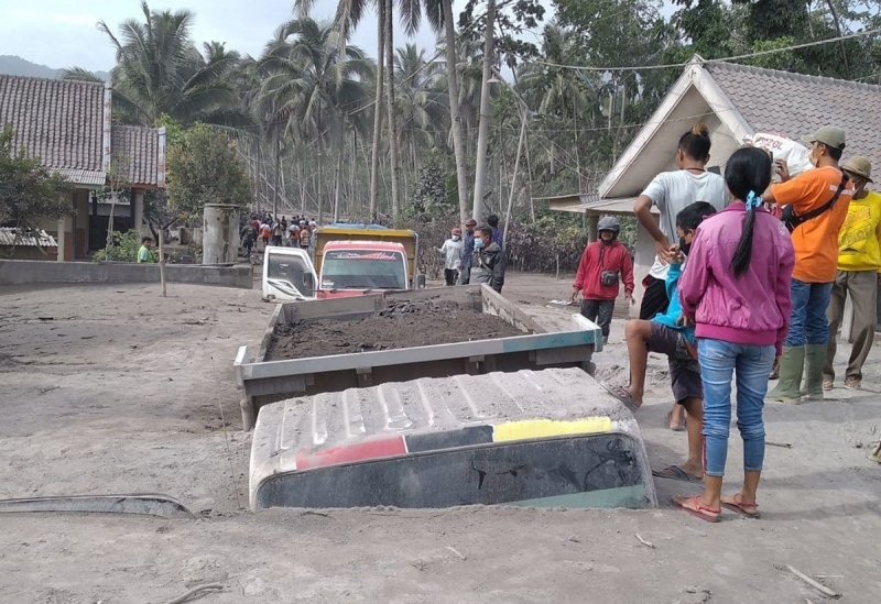 Một gia đình bị kẹt trong chiếc xe chở cát chờ lực lượng cứu hộ. (Nguồn: JPNN)