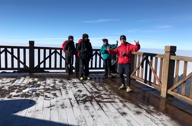 Tourists are overjoyed at the sight of frost on the famous peak. (Photo: VNA/VNS)