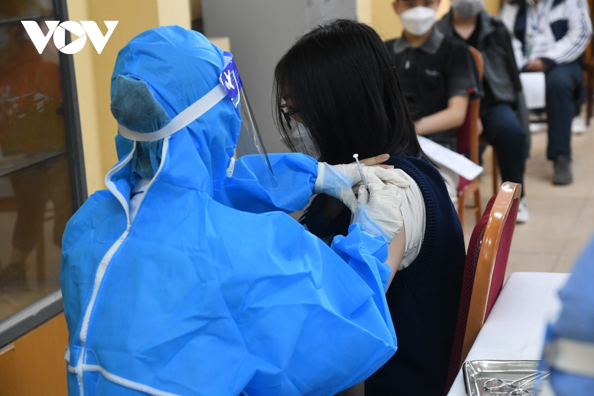 A student receives a shot of the Pfizer COVID-19 vaccine in Hanoi