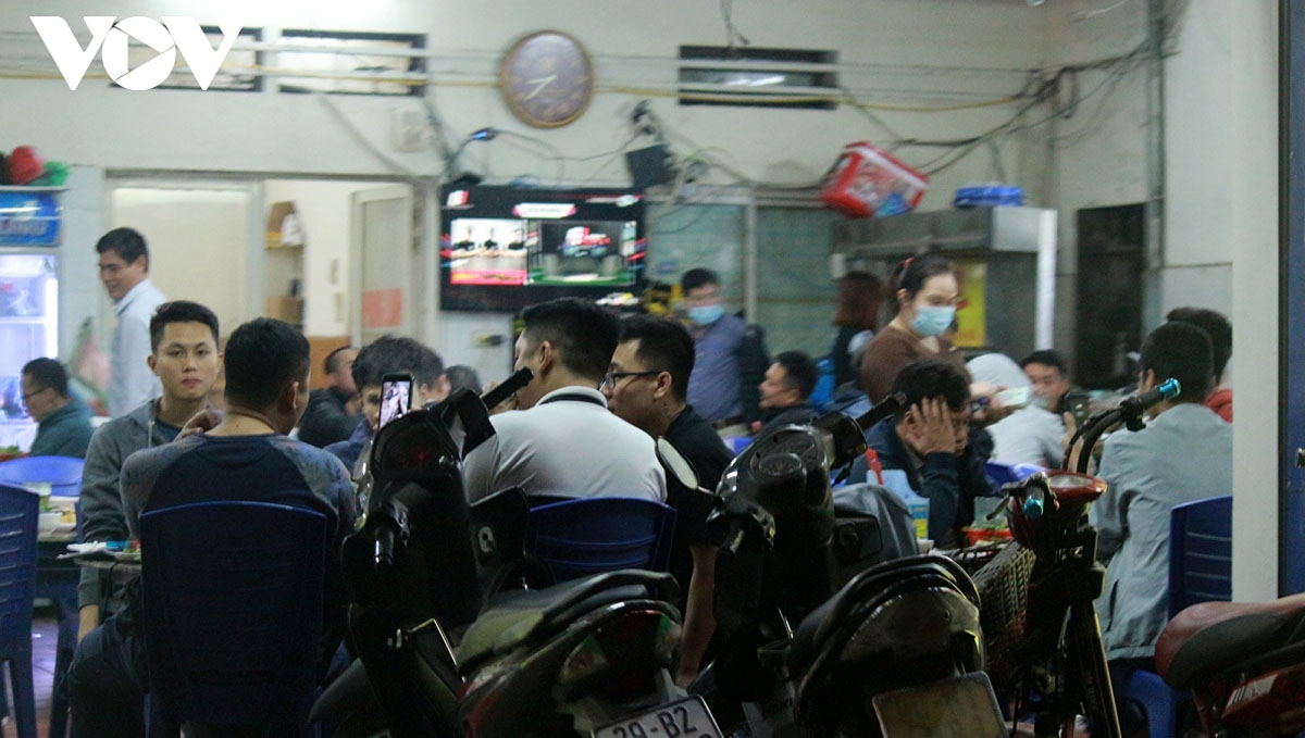 Crowds of people sit at street eateries in Hanoi despite the fact that the outbreak remains complicated in the city, with nearly 1,500 new cases recorded daily.