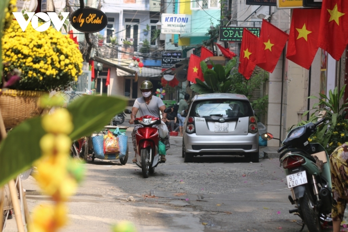 An alley on Pham Ngu Lao street is covered with festive lanterns and yellow apricot flowers signaling the spring is coming.