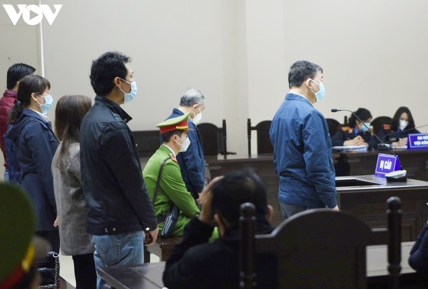Cựu Giám đốc BV Bạch Mai - Nguyễn Quốc Anh (áo xanh đứng trước) và các bị cáo đứng nghe tuyên án.