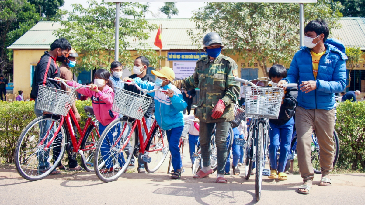 Phụ huynh và các em học sinh sau buổi lễ tại trường Tiểu học Thuận, phấn khởi mang xe đạp về nhà.