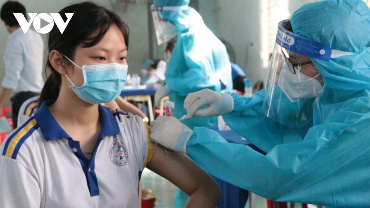A teenage girl receives a COVID-19 vaccine shot.