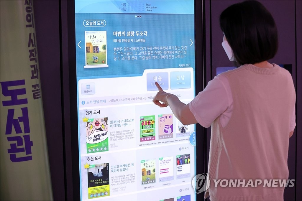 Một công dân sử dụng thư viện thông minh tại ga tàu điện ngầm ở Seoul.  (Ảnh: Yonhap)