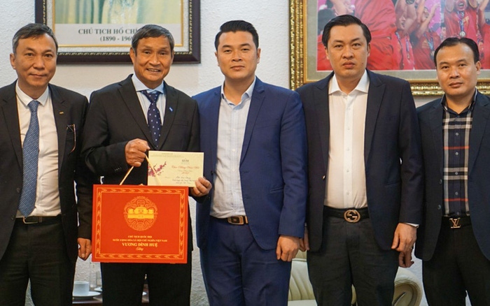 Cán bộ Văn phòng Quốc hội trao quà Tết và thiệp chúc mừng của Chủ tịch Quốc hội Vương Đình Huệ cho HLV trưởng Mai Đức Chung.