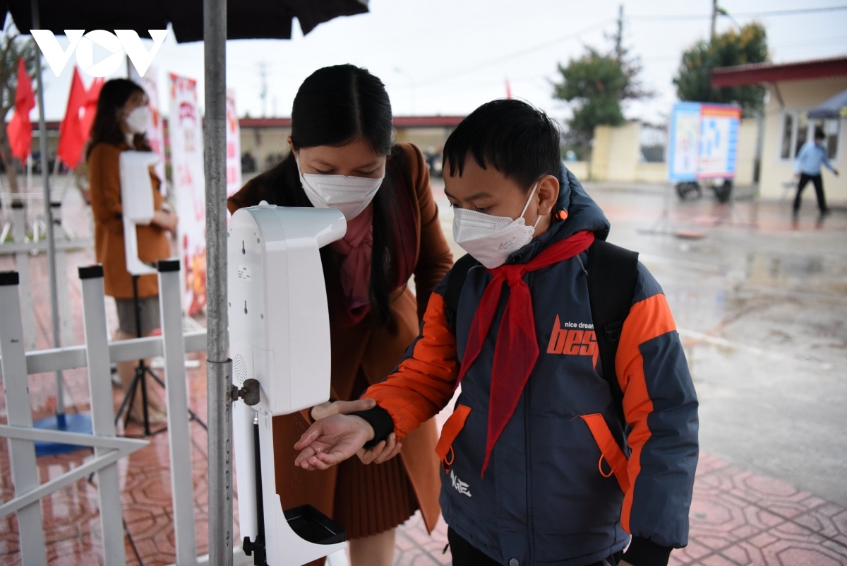 Teachers check the pupils’ body temperature and instruct them to wash their hands with sanitizer before entering the classroom.