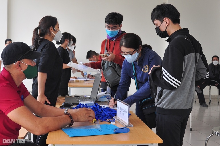 Volunteers guide new students to conduct admission procedures at the Ho Chi Minh City University of Technology (HUTECH). The students are required to strictly follow COVID-19 recommendations, including wearing face masks.