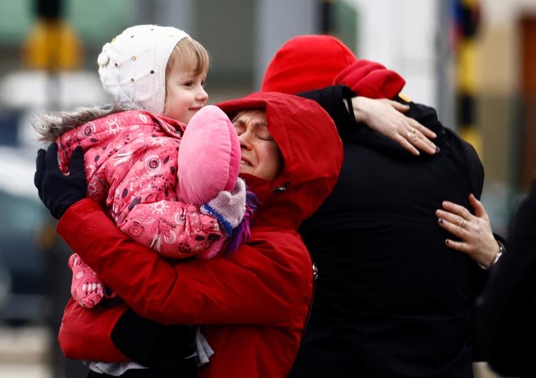 Các thành viên trong một gia đình ôm chầm lấy nhau sau khi băng qua biên giới Ukraine tới Kroscienko, Ba Lan.