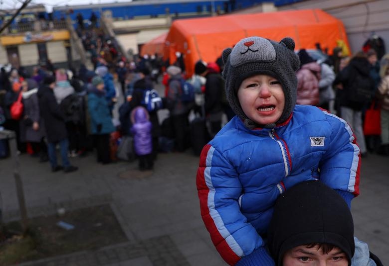 Một em bé khóc trên vai của người anh khi tìm kiếm mẹ bên ngoài nhà ga xe lửa ở Lviv, Ukraine ngày 8/3.