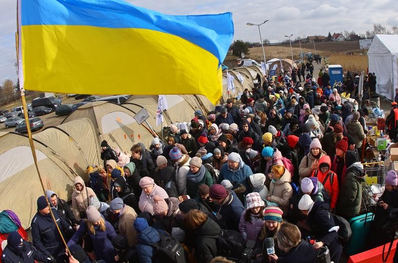 Người dân đang lũ lượt kéo đến một trạm xe buýt để băng qua biên giới Ukraine đến Ba Lan.