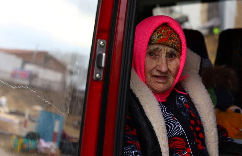 Cụ bà Natasha, 83 tuổi, người từng trải qua Thế chiến thứ hai, nhìn ra ngoài xe buýt đang đi qua biên giới Ukraine để đến Ba Lan.