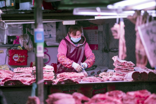 Người bán hàng chuẩn bị thịt lợn tại một khu chợ ở Thượng Hải. (Ảnh: Bloomberg)