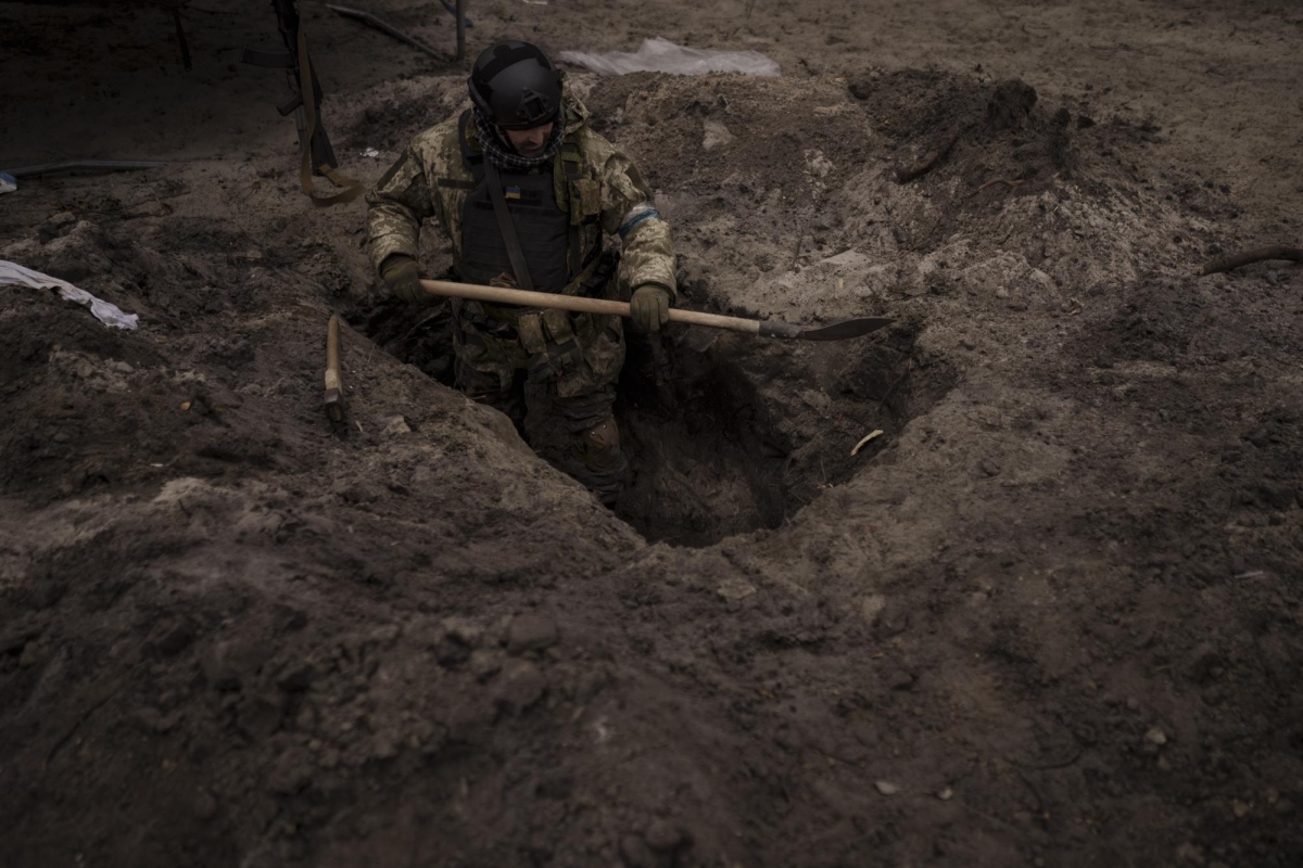 Một quân nhân Ukraine đào hố cá nhân ở ngoại ô Kiev.