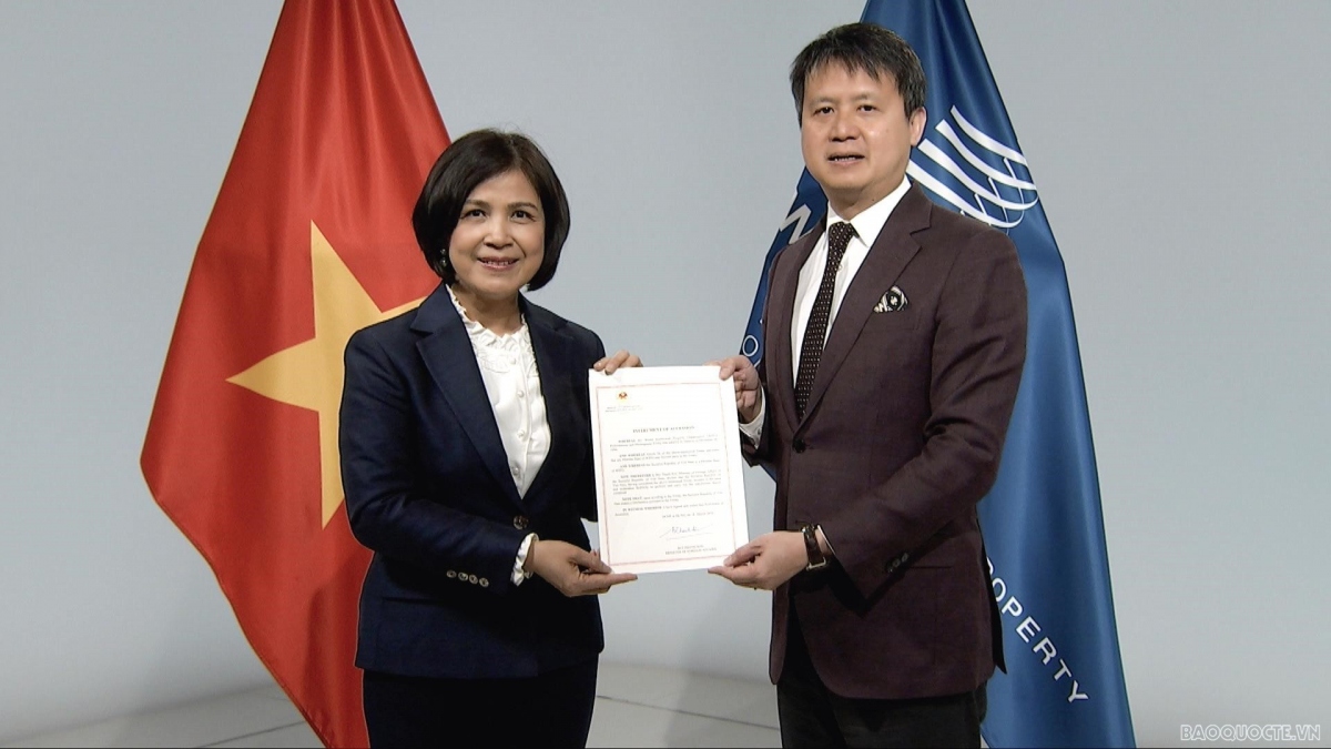 Ambassador Le Thi Tuyet Mai hands over a document on Vietnam's accession to the WPPT to WIPO Director General Daren Tang. (Photo: baoquocte.vn)