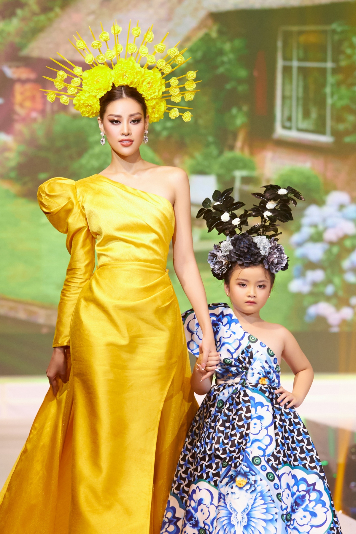 Sang phần trình diễn thứ hai, Hoa hậu Khánh Vân diện nguyên bộ đầm màu vàng rực, cùng mũ to đính hoa giúp tôn vinh vóc dáng và chiều cao nổi bật của đương kim Hoa hậu Hoàn vũ Việt Nam.